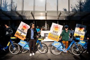 A group of Summer of Heat protestors with decorated Citi bikes blocking the doors to citi bank